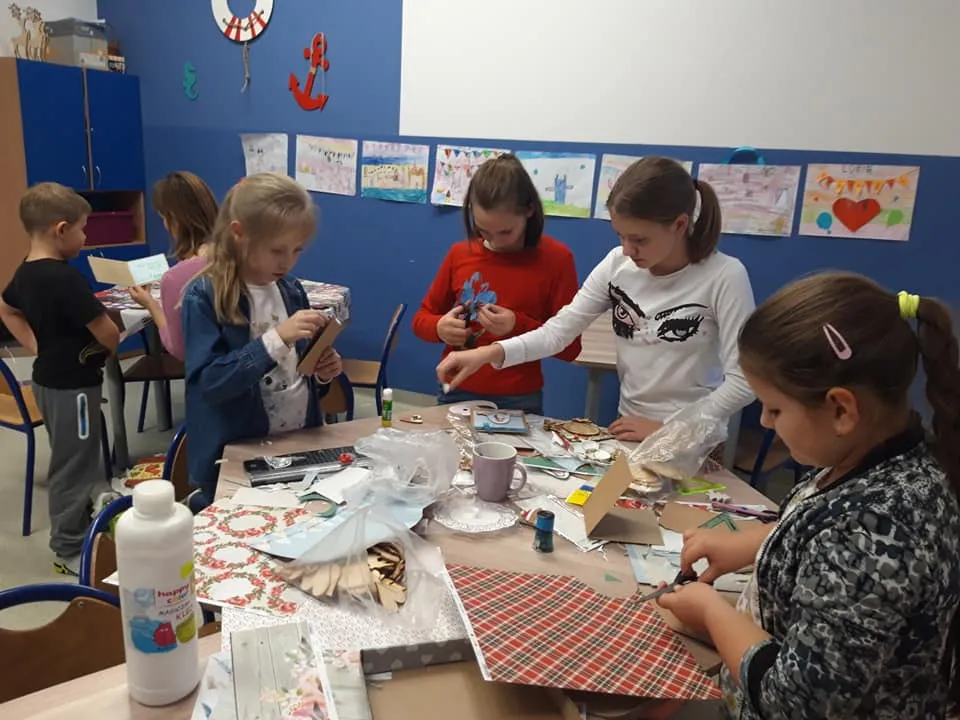 Obraz przedstawia wychowanków SPWD podczas wykonywania dekoracji na kiermasz świąteczny. 