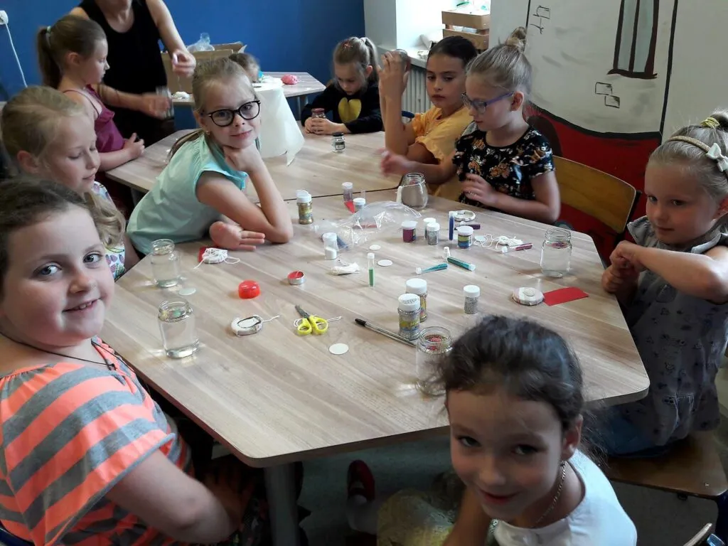 Obraz przedstawia wychowanków SPWD podczas zajęć antystresowych.  Podczas zajęć wychowankowie odkrywają sposoby skutecznego radzenia sobie ze stresem. Na zdjęciu możemy ujrzeć jeden ze sposób radzenia sobie ze stresem przy użyciu słoiczka.