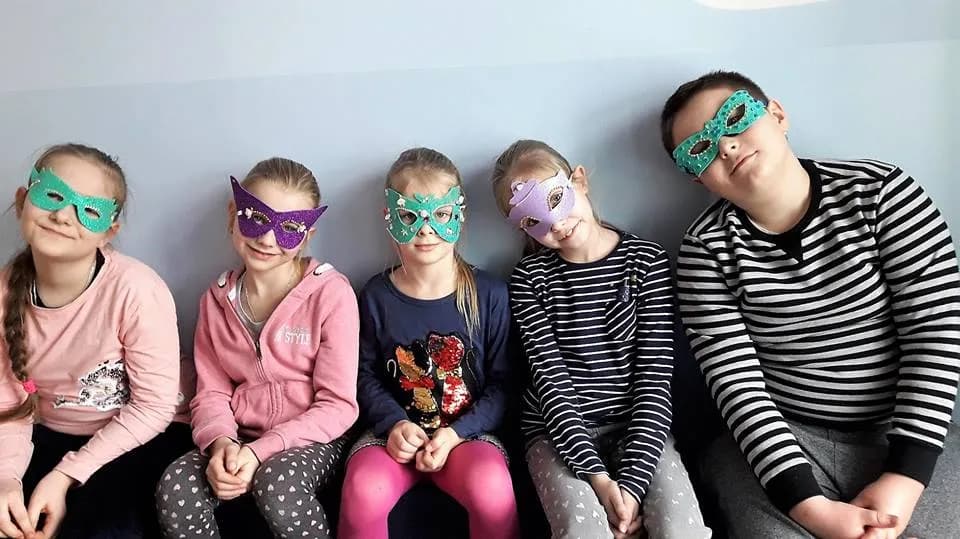 Obraz przedstawia wychowanków w maskach karnawałowych.