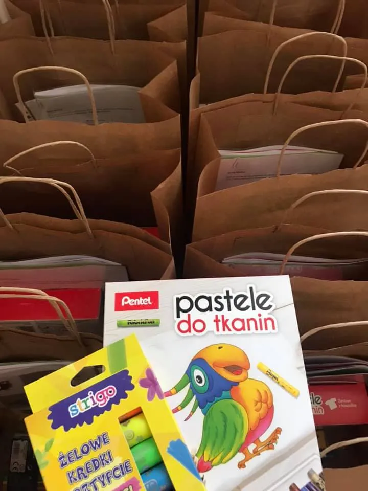 Obraz przedstawia prezenty, które otrzymał każdy z wychowanków placówki. W prezentach znajdują się różnego rodzaju przybory plastyczne.