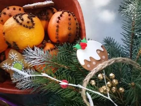 Zdjęcie przedstawia gałązkę choinki oraz ręcznie wykonane dekoracje świąteczne.