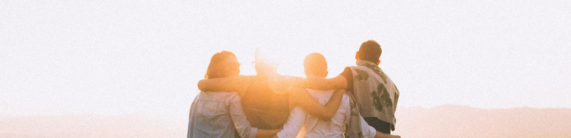 Grupa ludzi stojąca razem przodem do słońca