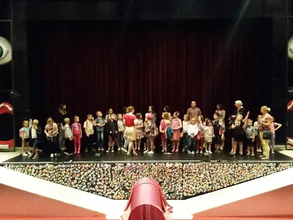 Zdjęcie przedstawia dzieci na scenie teatru z aktorami tuż po spektaklu pt. "Pinokio", na który dzieci zostały zaproszone.