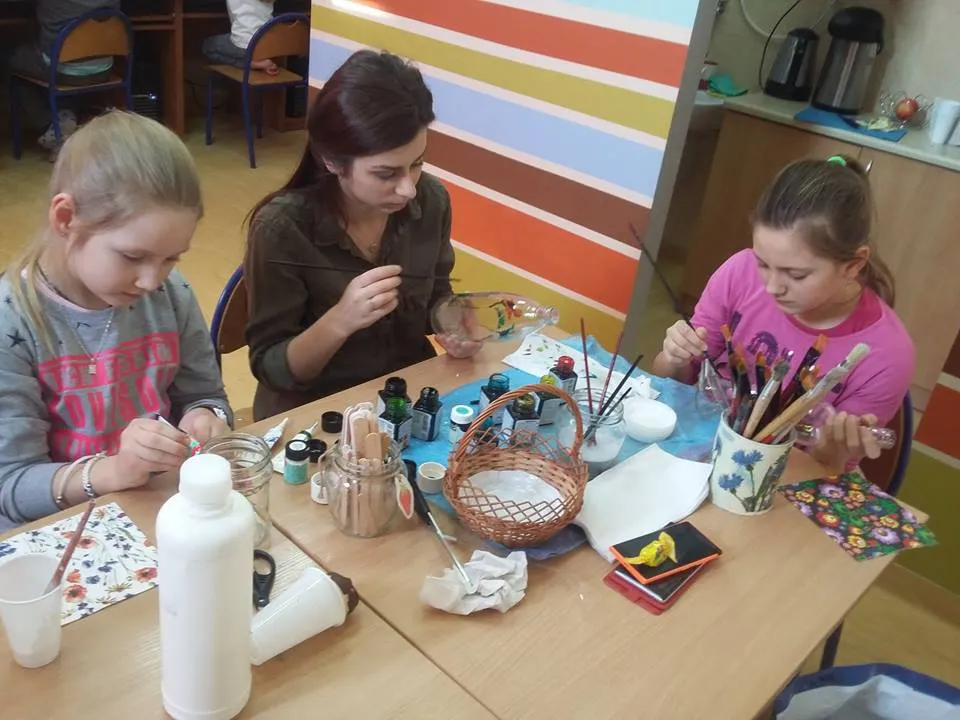 Zdjęcie przedstawia dzieci wraz z wychowawcą tworzących kolejne rękodzieła.