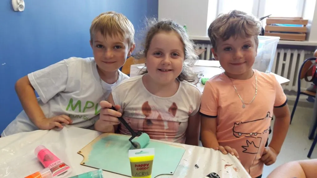 Obraz przedstawia wychowanków SPWD podczas zajęć artystycznego rękodzieła.